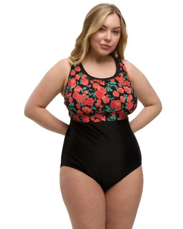 Woman wearing the Lida mastectomy one-piece swimsuit, black with a red rose-print bodice, front view