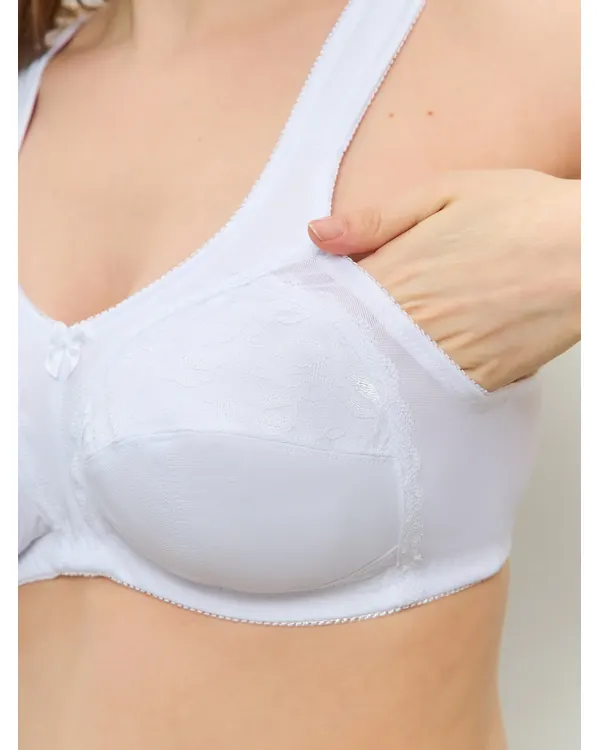 Hand opening the pocket inside the white lace mastectomy bra
